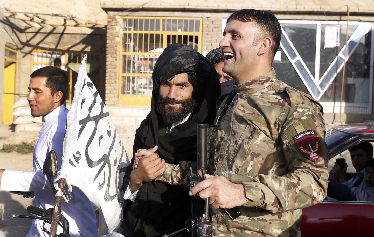 Talibani võitleja ja Afganistani sõjaväelane sõbralikult kätt surumas.