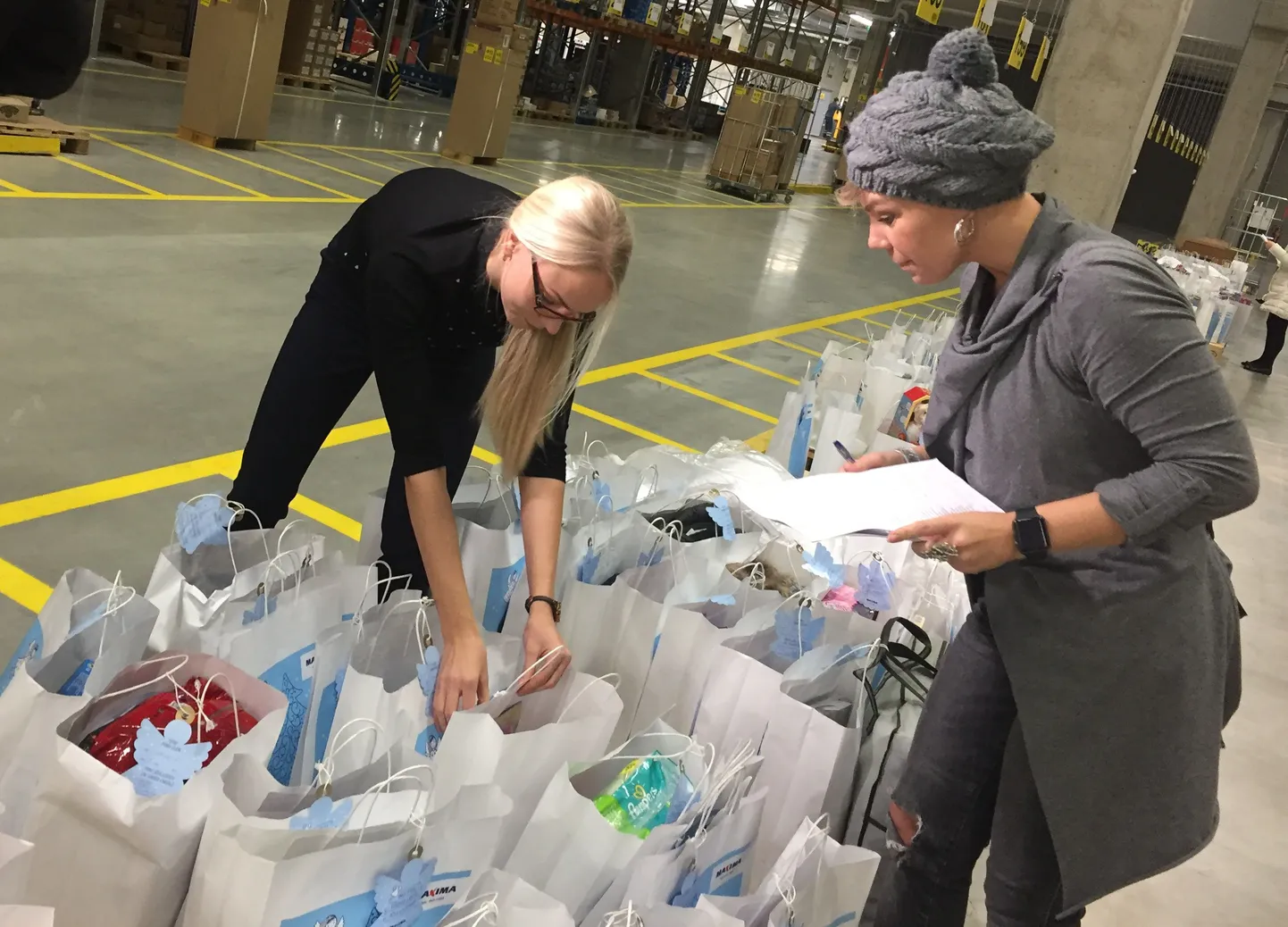Inglipuu patroon Gerli Padar Maxima logistikakeskuses kingitusi üle vaatamas.
