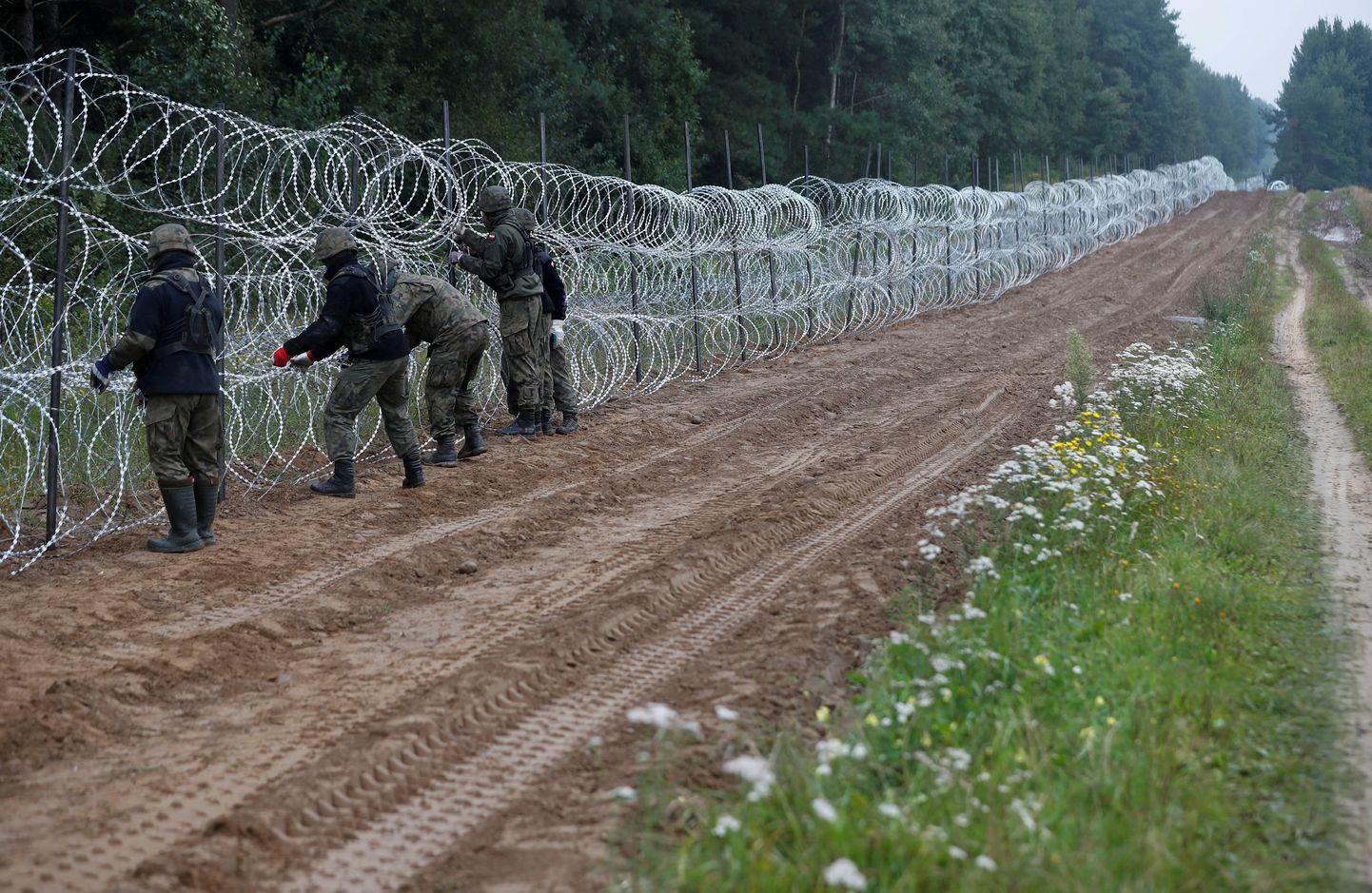 Poola sõdurid ehitamas traattõket Poola-Valgevene piirile.