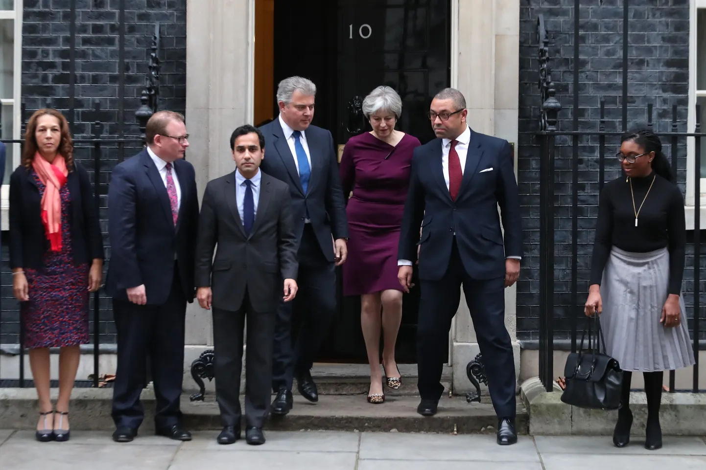 Theresa May (keskel) esmaspäeval Londonis Downing Street 10 asuva peaministri residentsi ees koos värskelt ametisse nimetatud uue Konservatiivse Partei esimehe Brandon Lewise (vasakult neljas) ja aseesimehe James Cleverly'ga (paremalt teine).