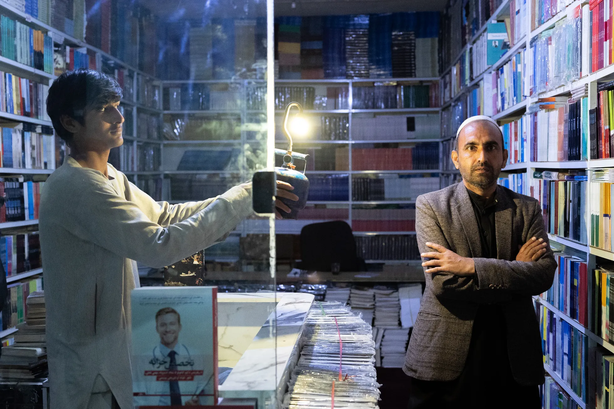 Afganistani poeet ja raamatukaupmees Ezat Ullah Zawab. Intervjuu olukorrast Talibani alla langenud riigis toimus pimedas raamatupoes elektrikatkestuse ajal, gaasilamp valgusallikaks. Vasakul gaasilambiga poeedi poeg Ata-Ullah Zawab.
