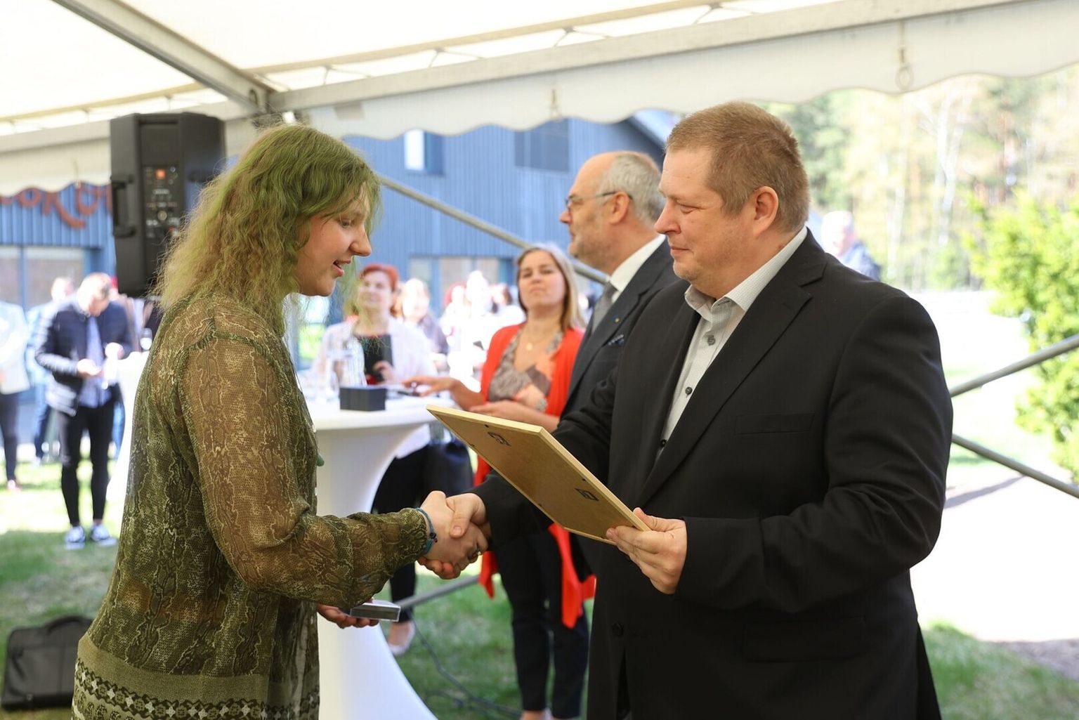 Antsla gümnaasiumi õpilane Tuuli Hommik võtab tänusõnad vastu keskkonnaminister Erki Savisaarelt.
