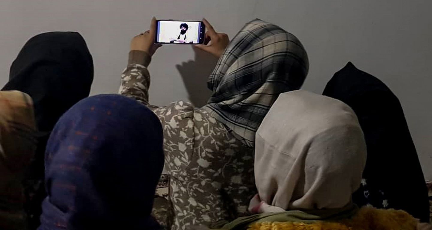 Афганские женщины в столице страны Кабуле смотрят по телефону проповедь министра высшего образования.