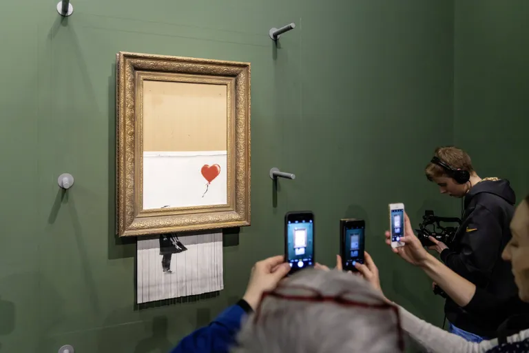 Banksy teose «Tüdruk õhupalliga» pooleldi hävinud versioon.