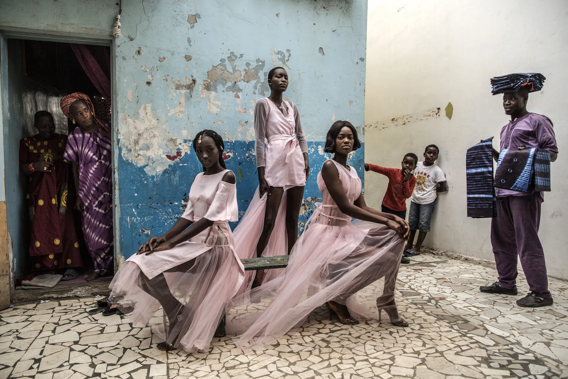 Dakari mood. Diarra Ndiaye, Ndeye Fatou Mbaye ja Mariza Sakho poseerivad disainer Adama Parisi loominguga fotosessioonil uudishimulike kohalike silme all Senegali pealinnas Dakaris.
