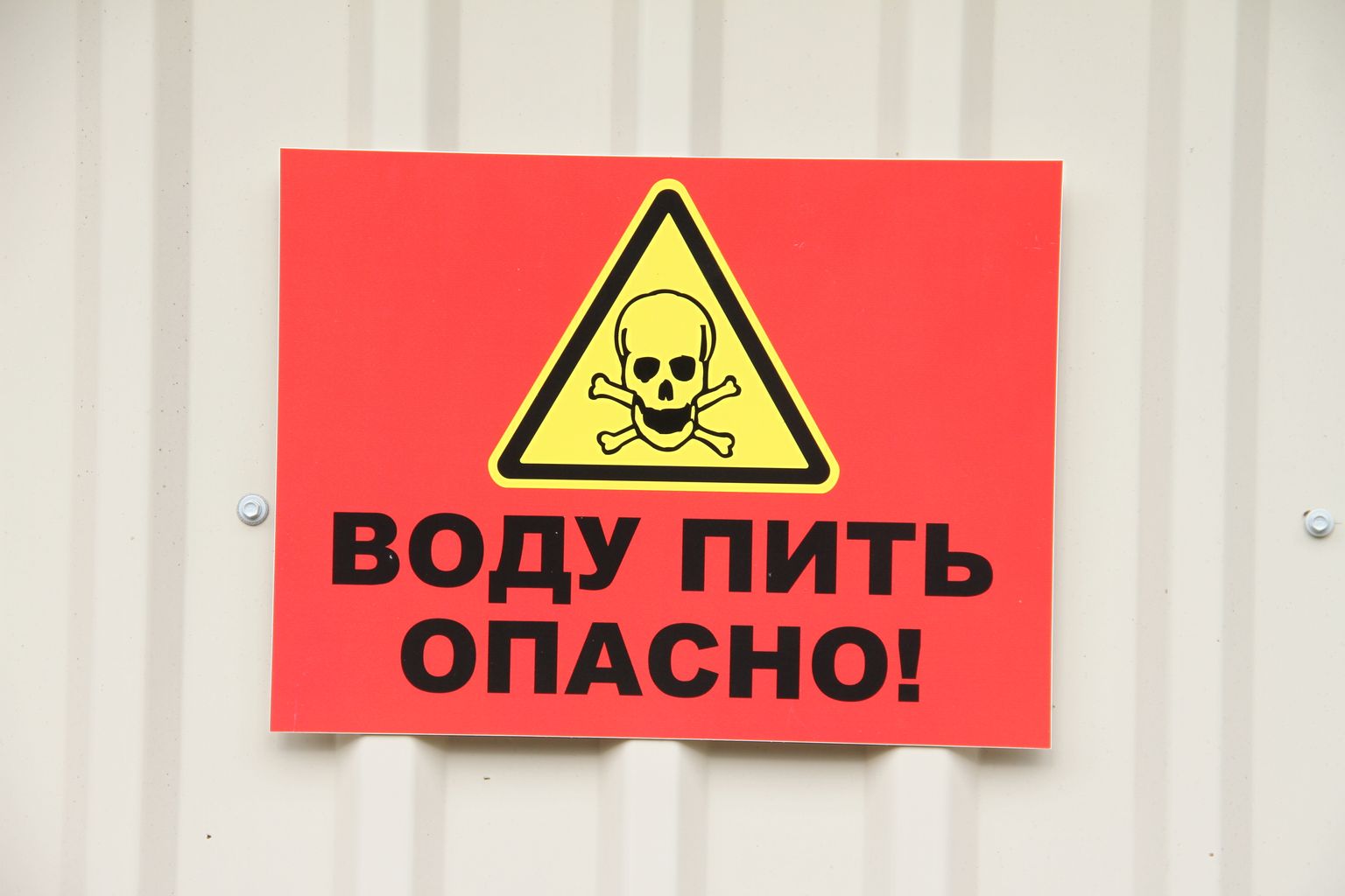 Самодельный предупреждающий знак на здании водокачки.