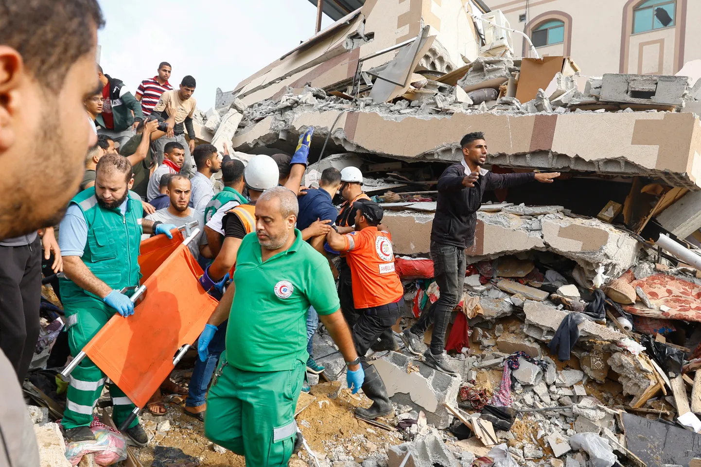 Palestiinlased otsimas ellujäänuid Iisraeli õhurünnakus tabamuse saanud maja rusudest Khan Younis 8. oktoobril 2023. aastal.