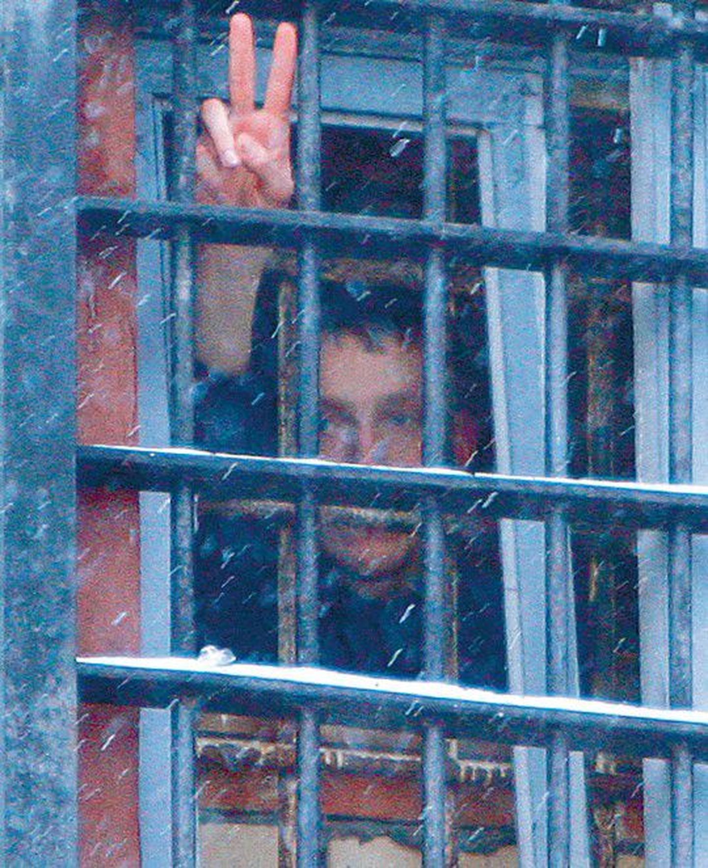 Один из  протестующих, задержанных 19 января, подает знаки из-за решетки. В пятницу, 21 января, состоялась инаугурация Александра Лукашенко, и он приступил к исполнению обязанностей президента Республики Беларусь на четвертый срок.