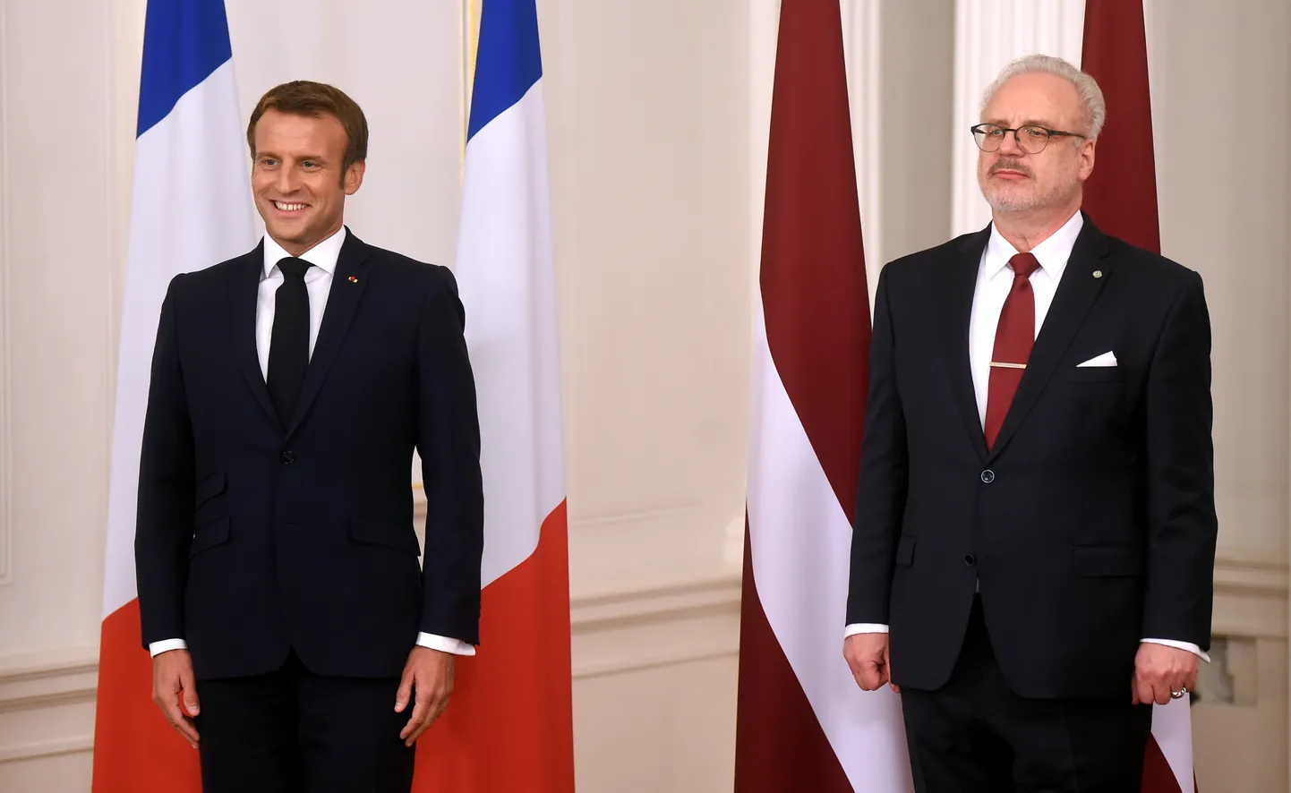 Latvijas prezidents Egils Levits (no labās) un Francijas prezidents Emanuels Makrons fotografējas pie abu valstu karogiem pirms paziņojuma presei Rīgas pilī.