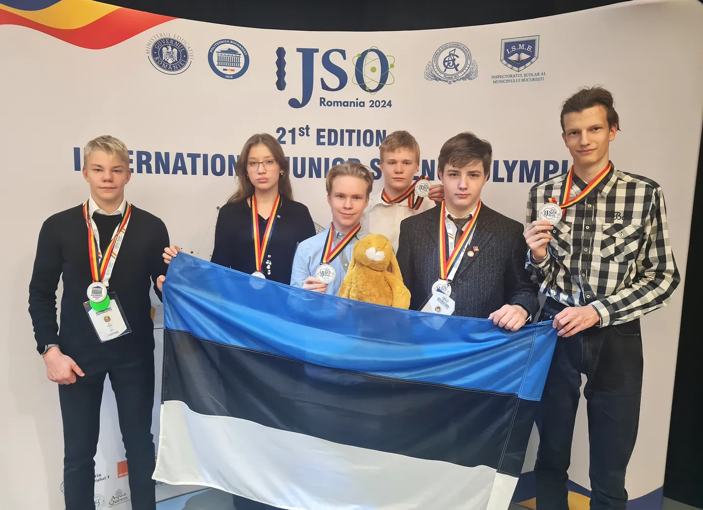 Eesti õpilaste võistkond Bukarestis loodusteaduste olümpiaadi lõputseremoonial, kõigil medalid kaelas.