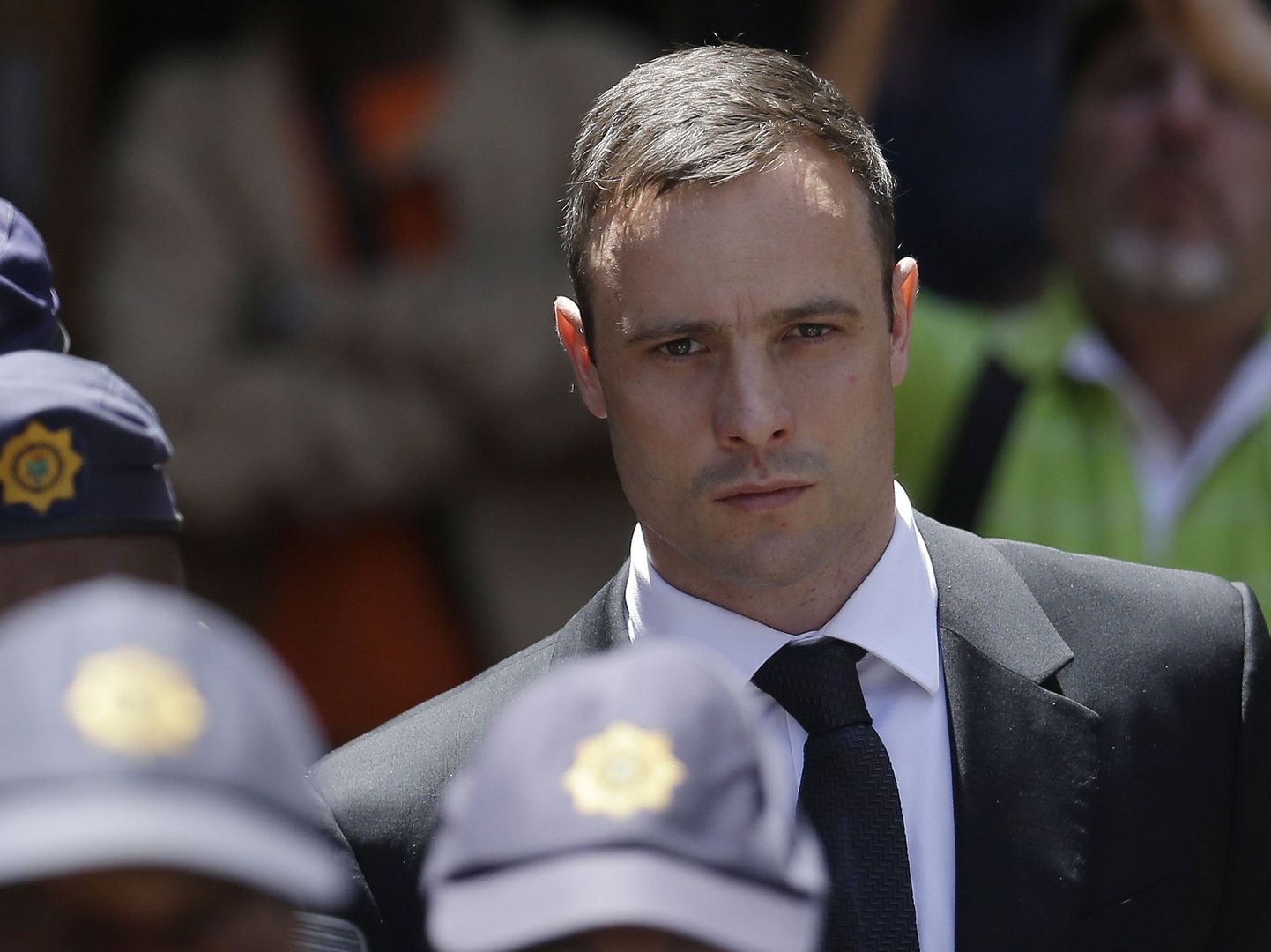 FILE - In this Friday, Oct. 17, 2014 file photo, Oscar Pistorius is escorted by police officers as he leaves the high court in Pretoria, South Africa.  Pistorius lawyers said Tuesday Feb. 27, 2015, that they will challenge a court decision to allow prosecutors to take the case to the Supreme Court seeking to convict the Olympic runner of the more serious crime of murder, for shooting girlfriend Reeva Steenkamp in 2013. (AP Photo/Themba Hadebe, FILE)