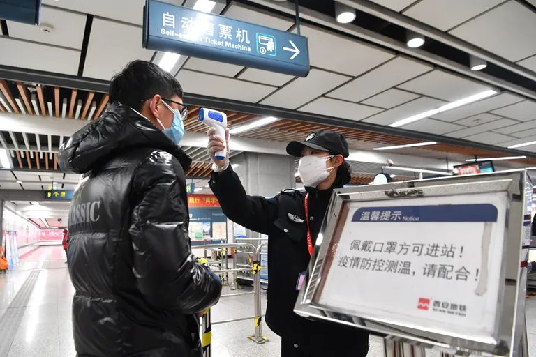 Turvatöötaja kontrollimas Shaanxi provintsi Xiani metroos reisija kehatemperatuuri.