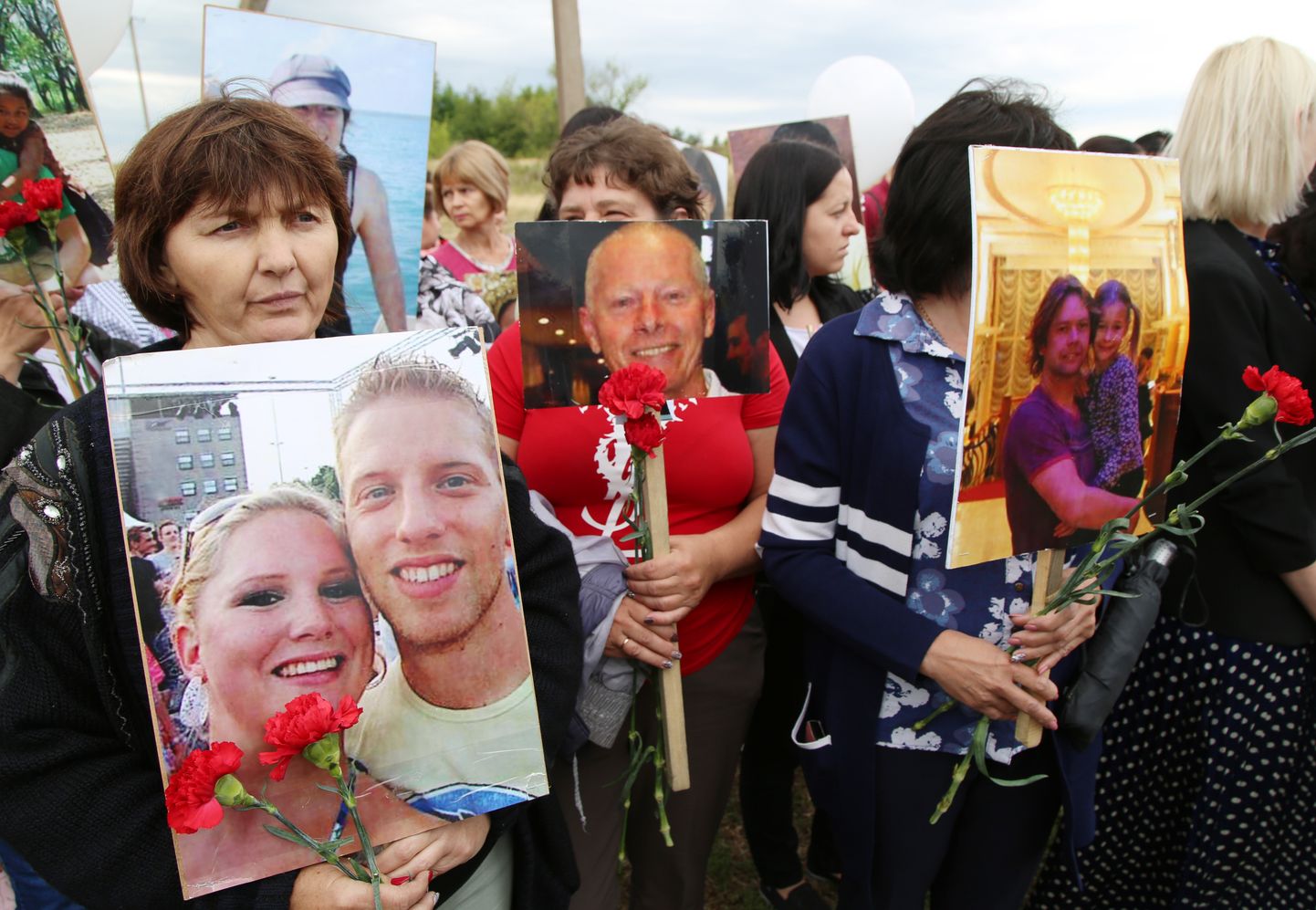 Inimesed MH17 katastroofi ohvrite fotodega lennuki allatulistamise aastapäeval Ida-Ukrainas Graboves 17. juuli 2020.