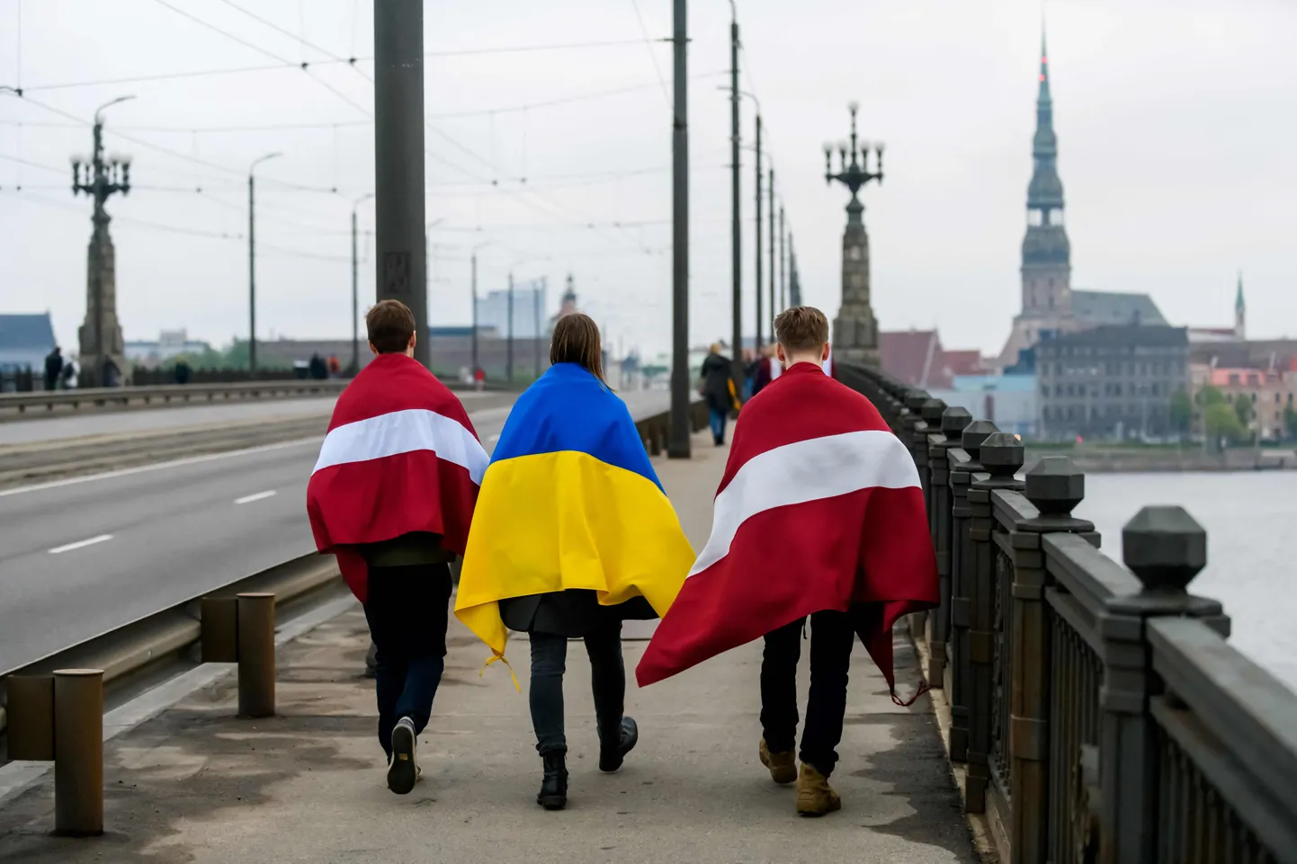 Люди с украинскими и латвийскими флагами в Риге после марша «За освобождение от советского наследия».