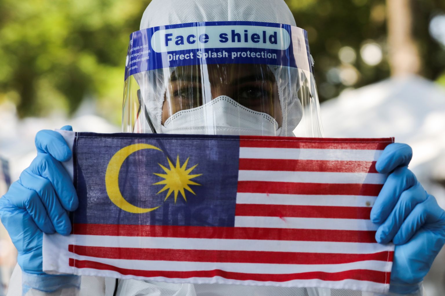 Malaisia meditsiinitöötaja hoiab Malaisa lippu.