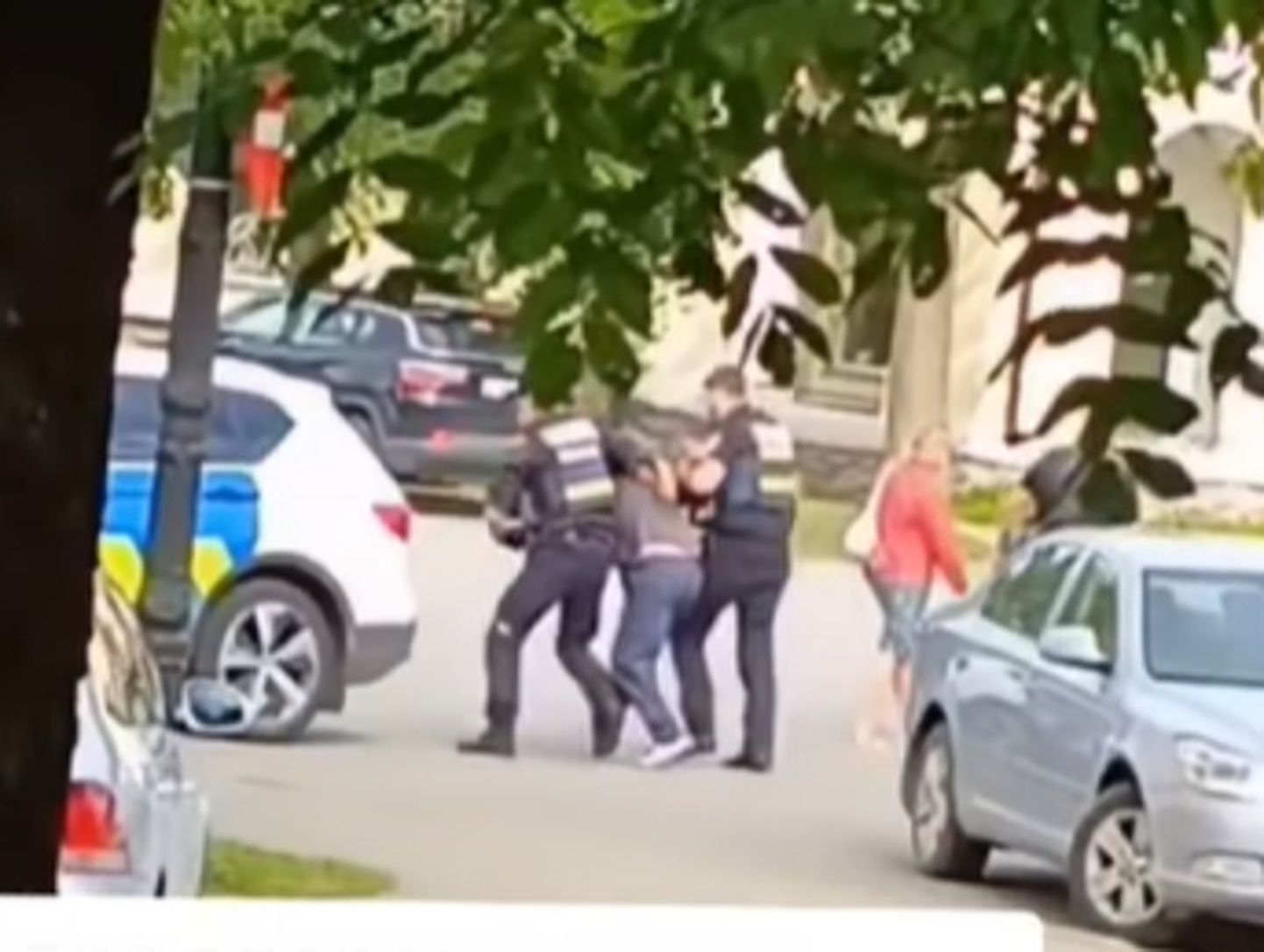 Сотрудники полиции уводят в свой автомобиль мужчину, который по данным PPA отказался починяться требованиям, после того, как в его машине была найдена георгиевская лента, Кохтла-Ярве, 4 сентября 2023 года.