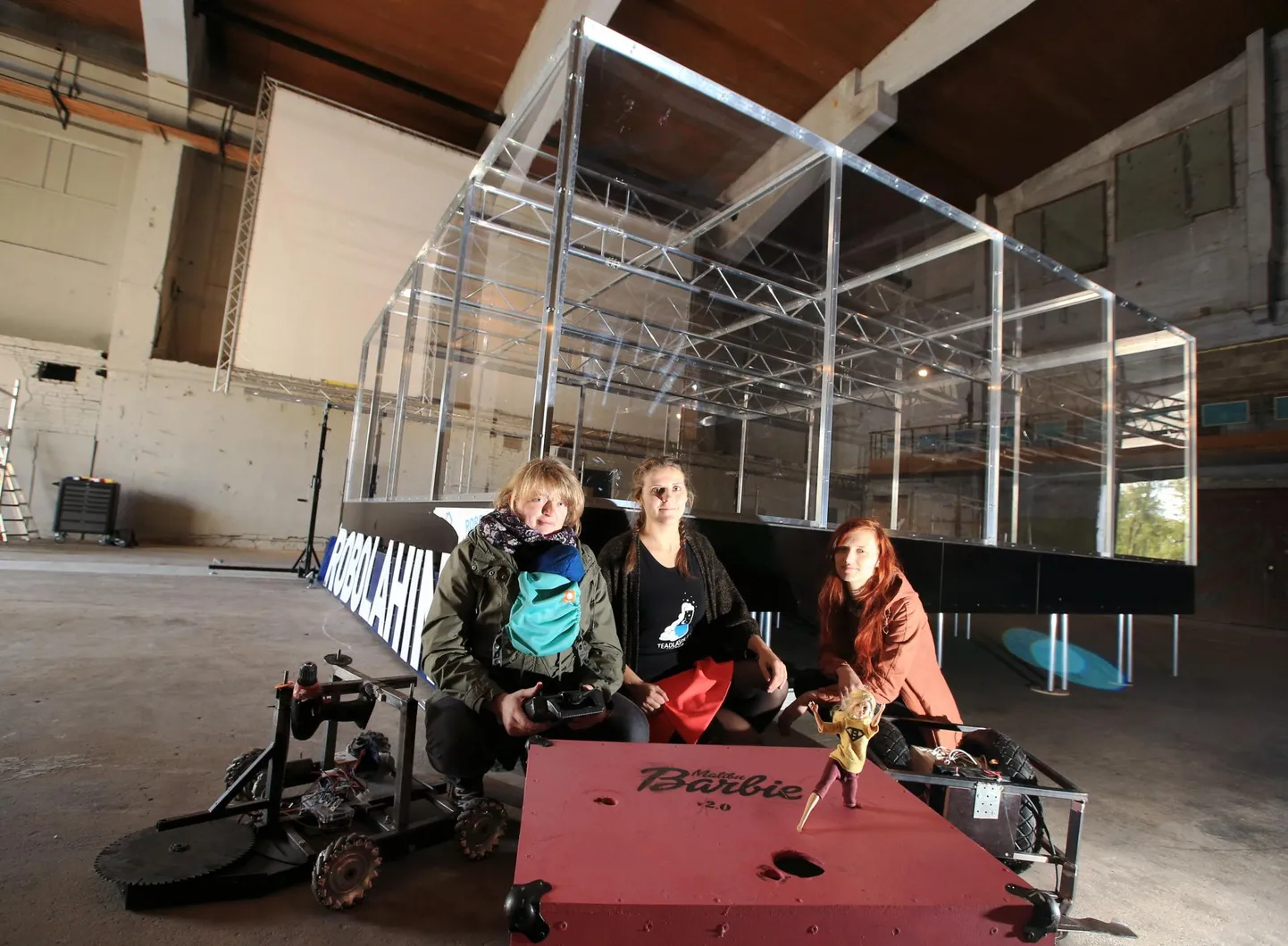 Vasakpoolne robot on juba küllalt vatti saanud, tänavu läheb Robolahingu võistlustulle parempoolne robot, millele monteerib naiskond külge barbi. Vasakult Helin Haga tütre Alikiga, Saile Mägi ja Annika Vesselov.