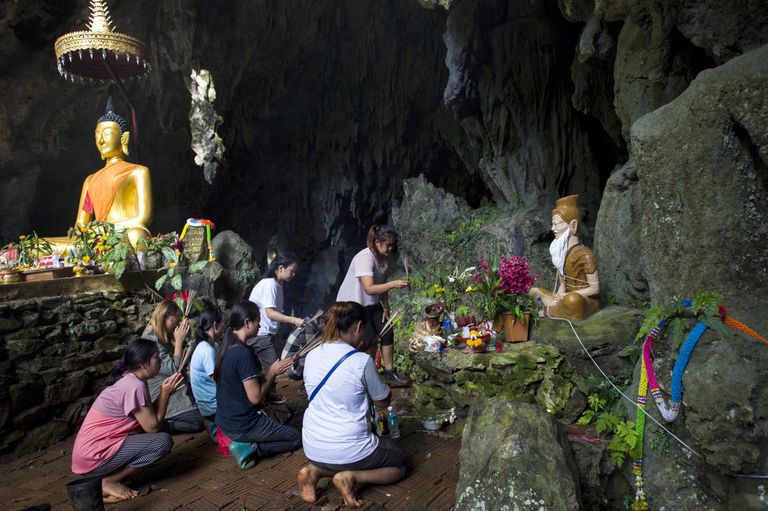 Tham Luangi koobastikus lõksus olevate poiste pereliikmed palvetamas