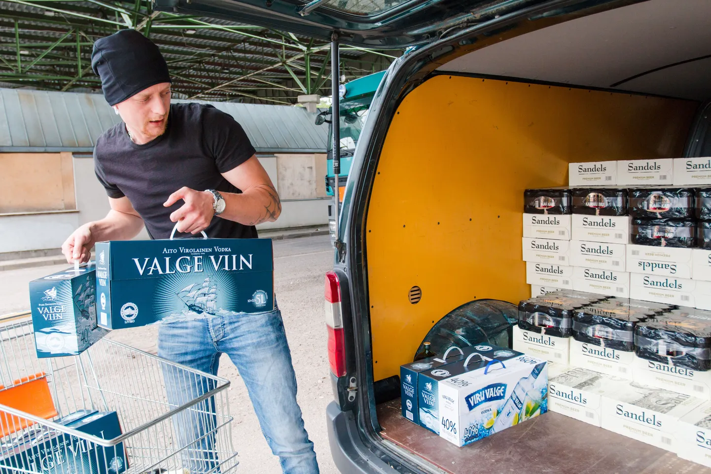Eesti-Läti piiril asuva kaupluse Alko1000 külastaja kaupa autosse panemas.