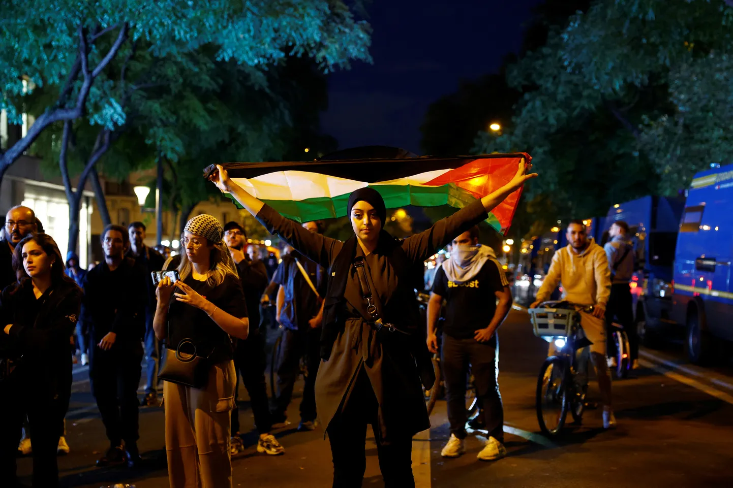 Sieviete nesankcionētas demonstrācijas laikā tur rokās palestīniešu karogu. Parīze, Francija, 2023. gada 12. oktobrī.