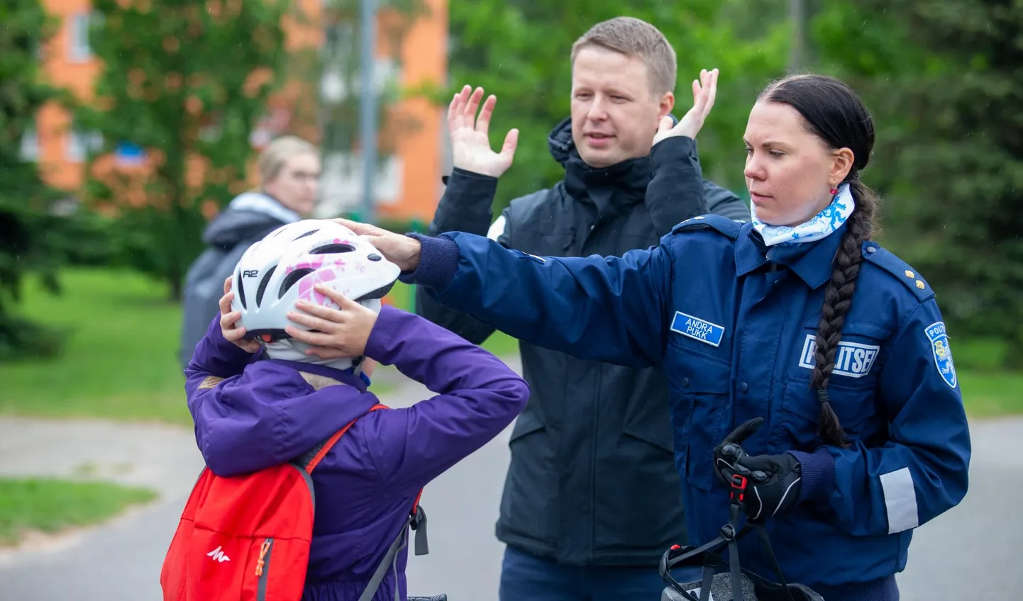 Eesti Terviseradade juhataja Alo Lõoke ja noorsoopolitseinik Andra Pukk jagasid reedel noorele jalgratturile õpetussõnu, kuidas kiivrit õigesti kanda. 