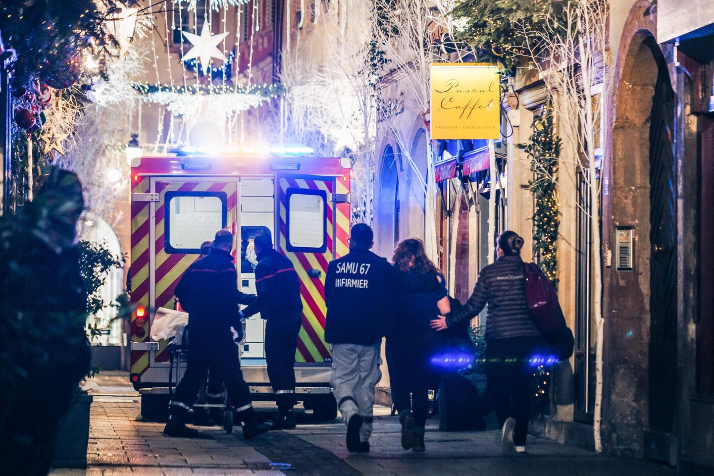 Emergency workers escort a woman after a shooting near the Christmas market in Strasbourg, eastern France, on December 11, 2018. - A gunman killed at least two people and seriously injured another 11 near the famed Christmas market in the French city of Strasbourg before fleeing the scene, security officials said. Police launched a manhunt after the killer opened fire at around 7pm local time (1800 GMT), sending crowds of evening shoppers fleeing for safety. (Photo by Abdesslam MIRDASS / AFP)