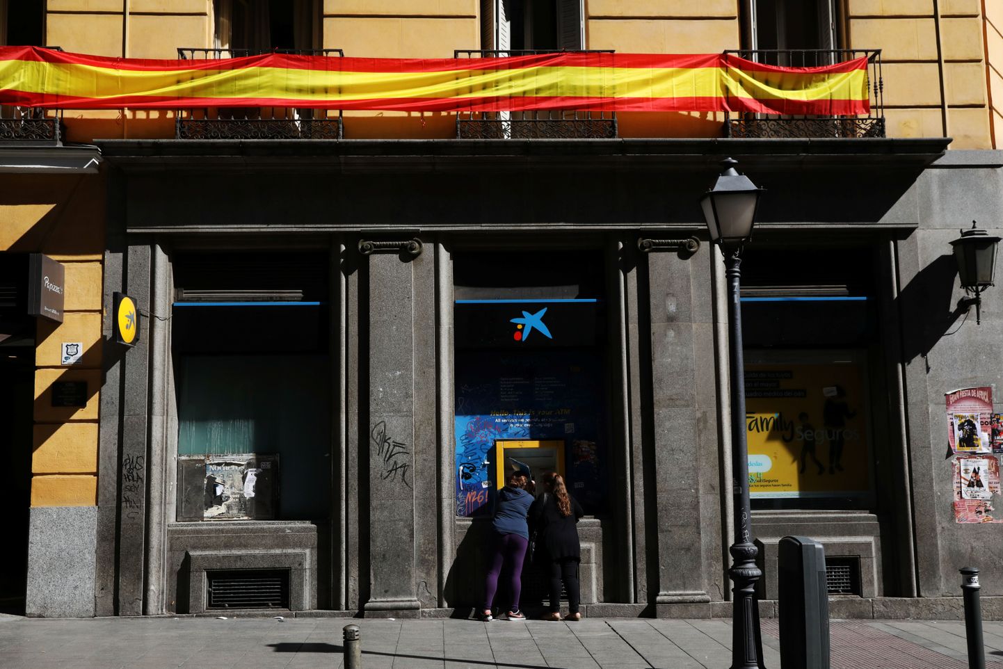 CaixaBanki sularahaautomaat Madridis, protestiks Kataloonias toimuva vastu Hispaania lipuvärvidesse ehitud rõdu all.