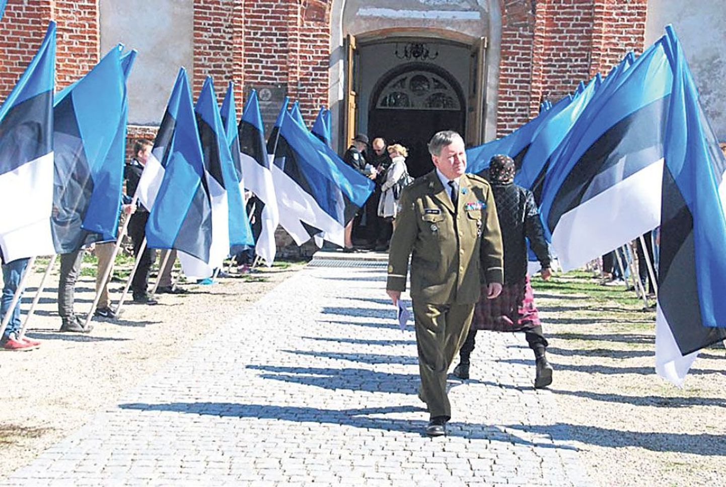 Saabuvaid kirikulisi tervitasid peasissekäigu esisel Sindi gümnaasiumi õpilased 20 suure sinimustvalge lipuga.
