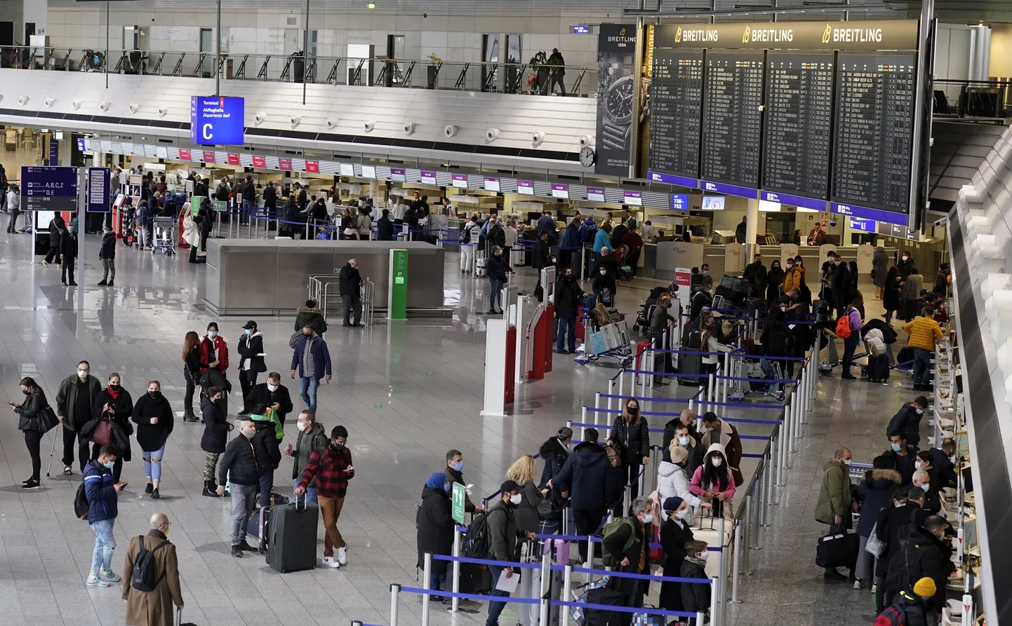 Люди стоят в очереди на регистрацию на рейс в международном аэропорту Франкфурта-на-Майне, Германия, 21 декабря 2020 года.