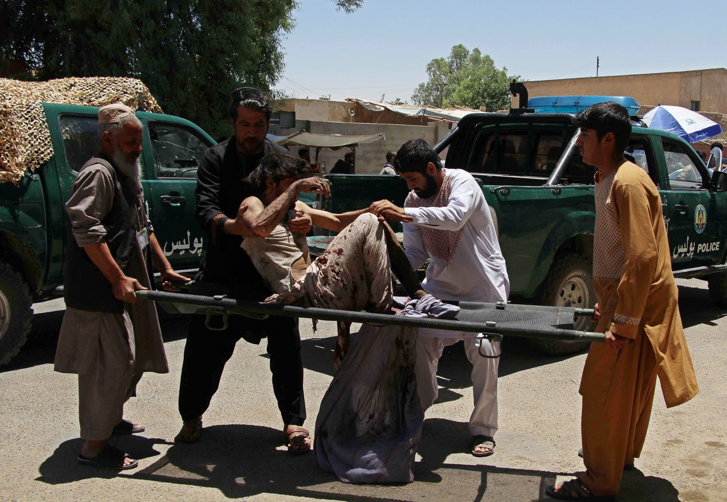 Afgaani mehed kannavad Lashkar Gah plahvatuses kannatada saanut.