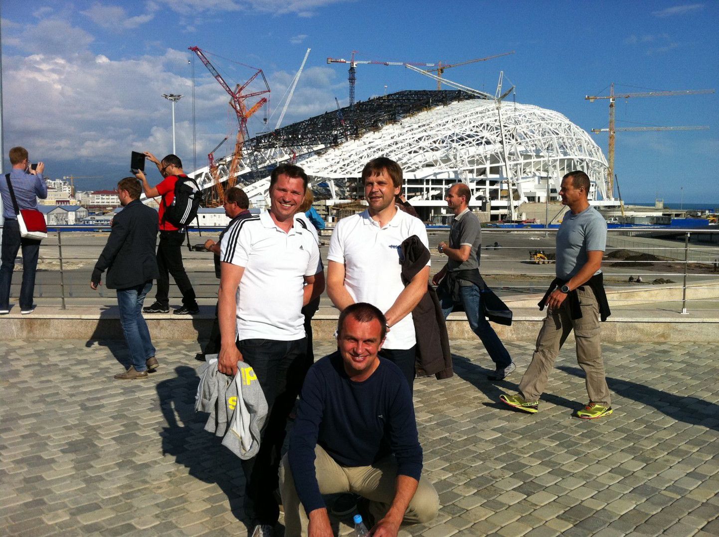 Otepää võistluste sekretär Kristjan Oja (vasakul)ja orgkomitee esimees Aivar Nigol koos Novo Mesto orgkomitee esindajaga hoone taustal, kus taliolümpiamängud avatakse.