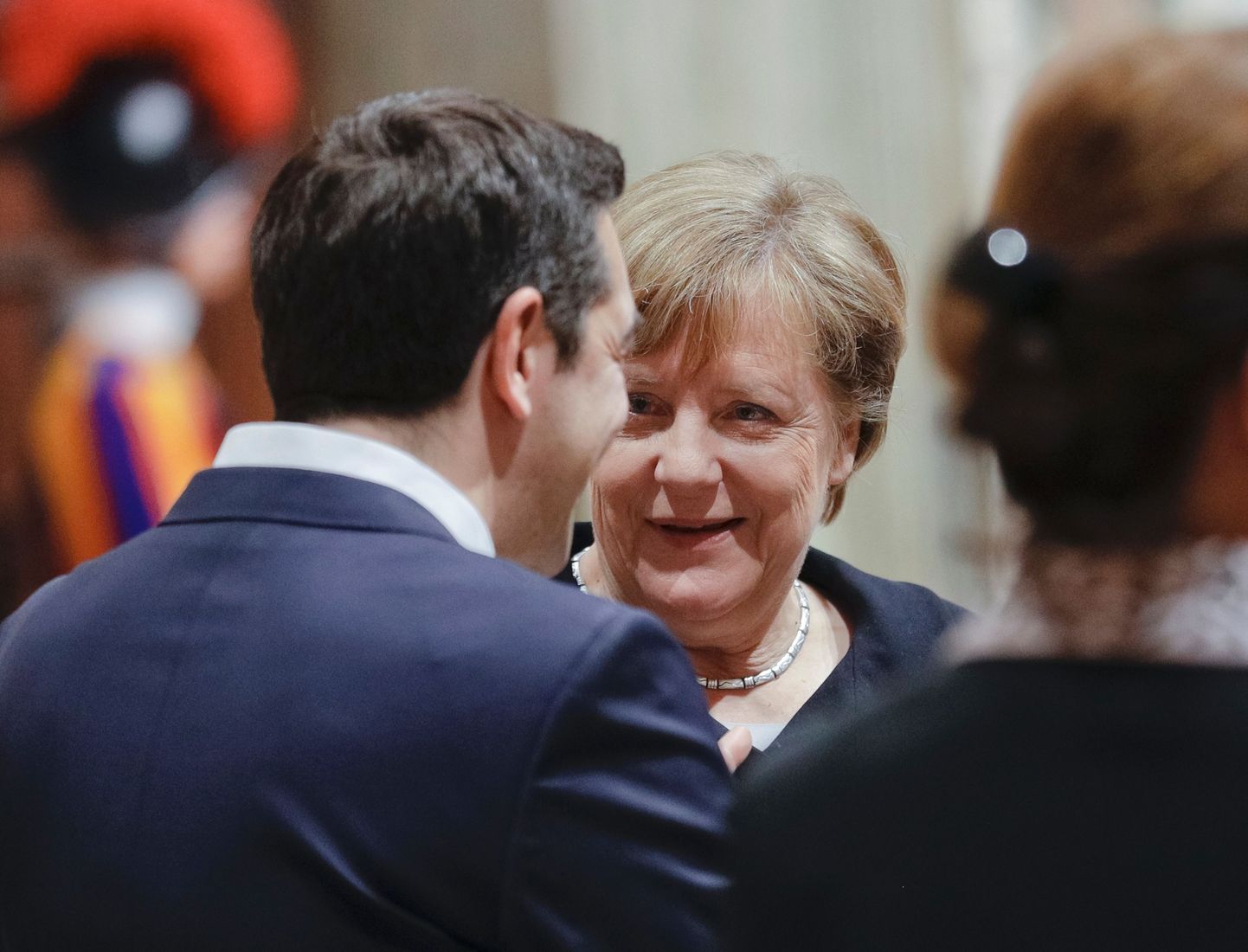 Saksamaa liidukantsler Angela Merkel (keskel) vestlemas kreeka peaminister Alexis Tsiprasega (vasakul seljaga).