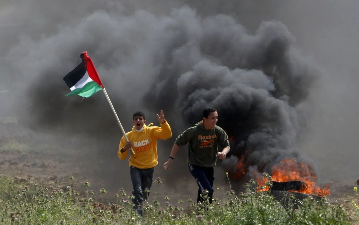 Palestiina noorukid jooksmas Iisraeli sõdurite eest kokkupõrgete ajal Nahal Ozi piiriületuspunkti juures Gaza linnast ida pool.