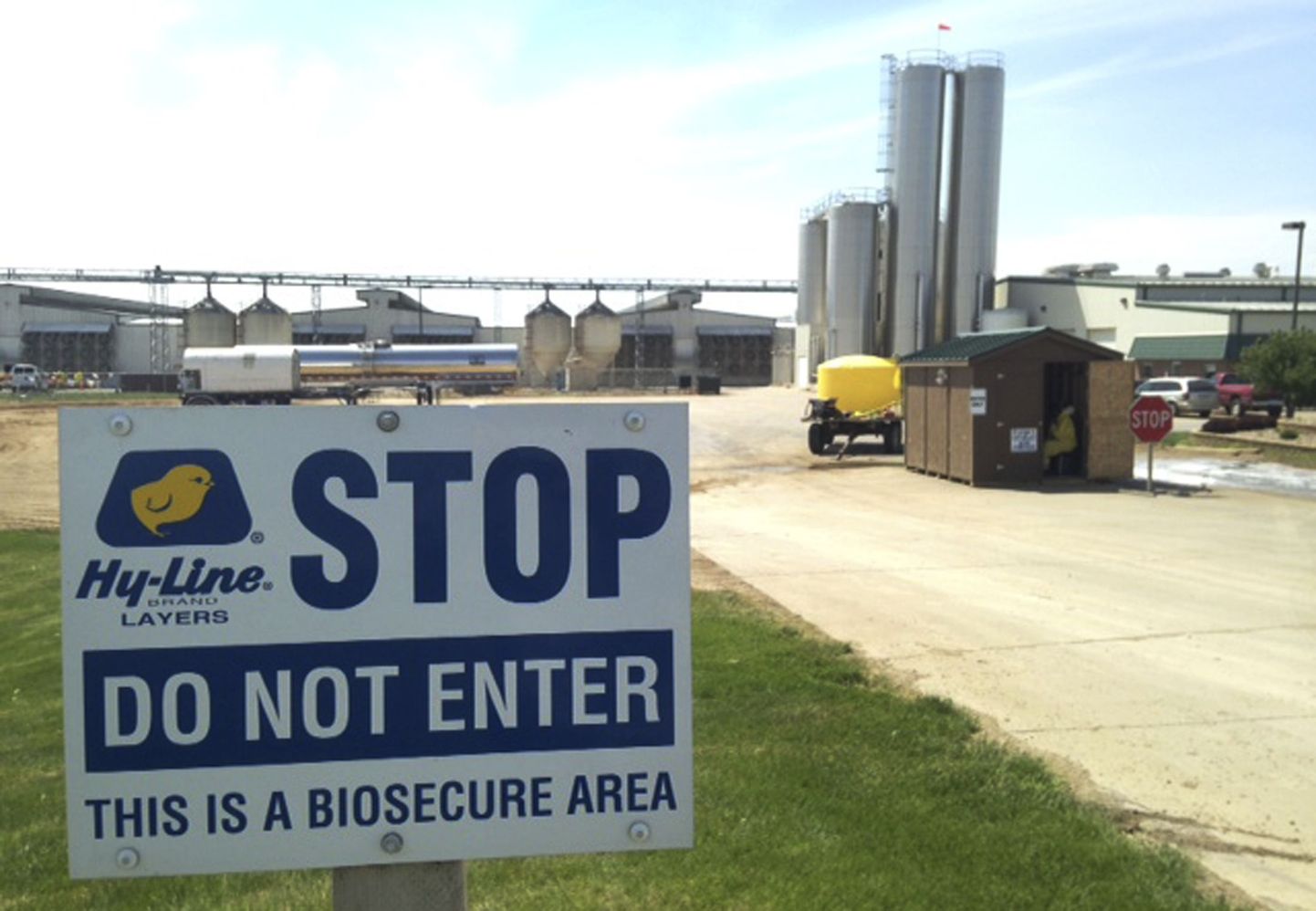 Hoiatussilt ja desinfektsioonipunkt Iowa kanafarmi sissesõidul.