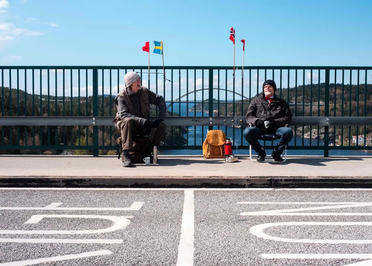 Два брата, живущие по разные стороны границы Швеции и Норвегии встречаются на мосту Свинесунд - каждый на своей стороне в период самоизоляции 2020 г.