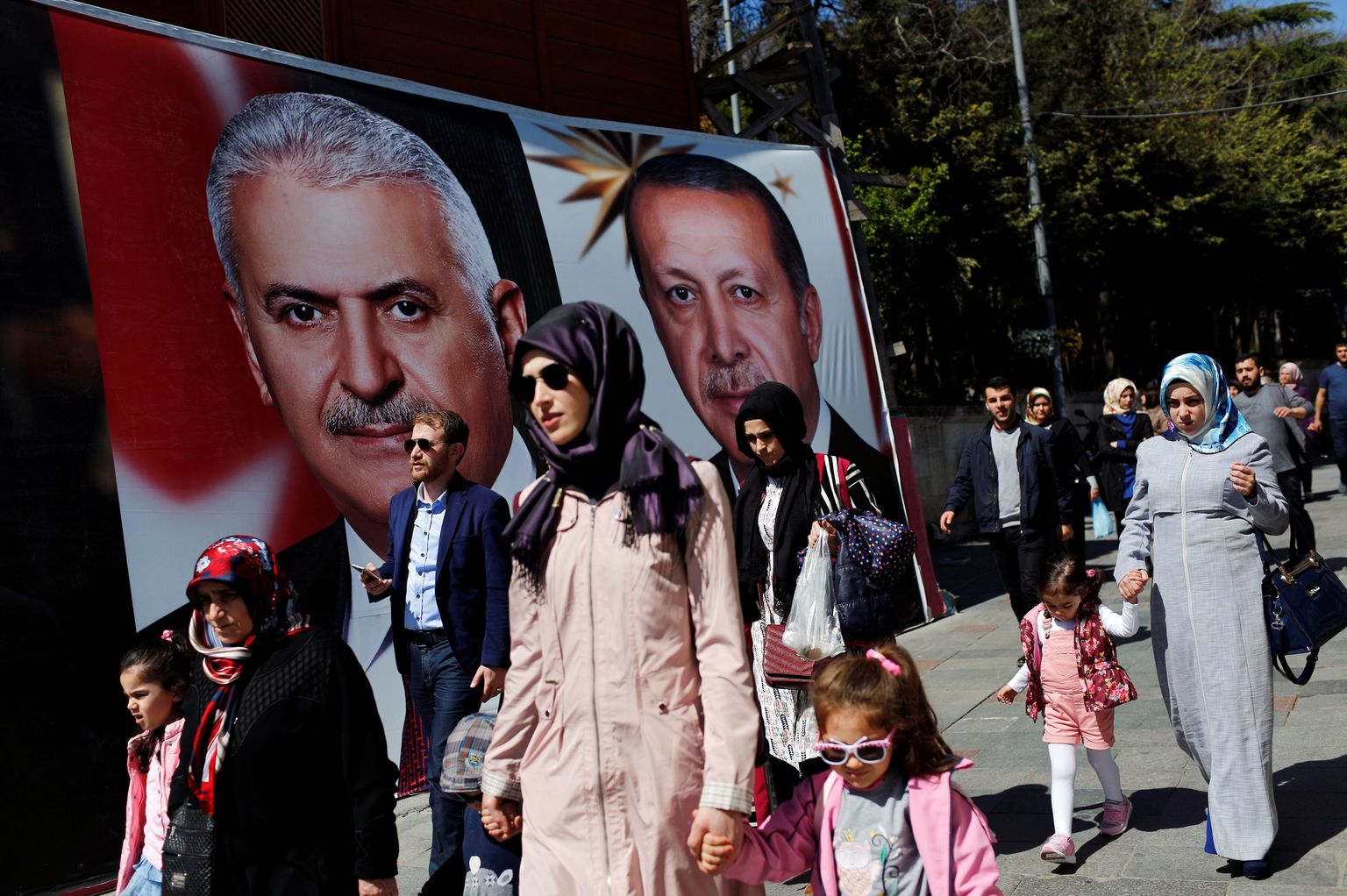 Istanbuli elanikud möödumas peaminister Binali Yildirimi ja president Recep Tayyip Erdogani piltidega kampaaniaplakateist.