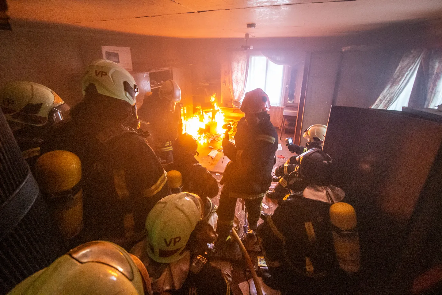 Пожарные спасатели работают в горящей и задымленной квартире. Фото сделано во время учений и носит иллюстративный характер.