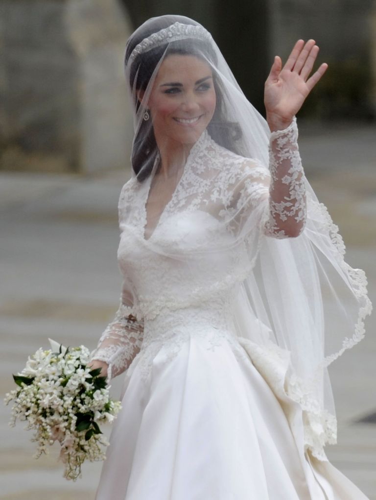 Кейт Миддлтон машет рукой, когда она прибыла к западным дверям Вестминстерского аббатства в Лондоне на свою свадьбу с принцем Уильямом, 29 апреля 2011 года.