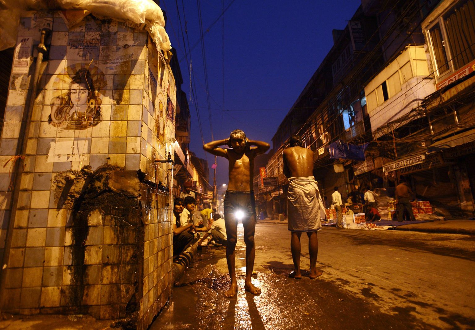 A man takes a bath along the streets of Delhi October 22, 2012. REUTERS/Navesh Chitrakar (INDIA - Tags: SOCIETY)