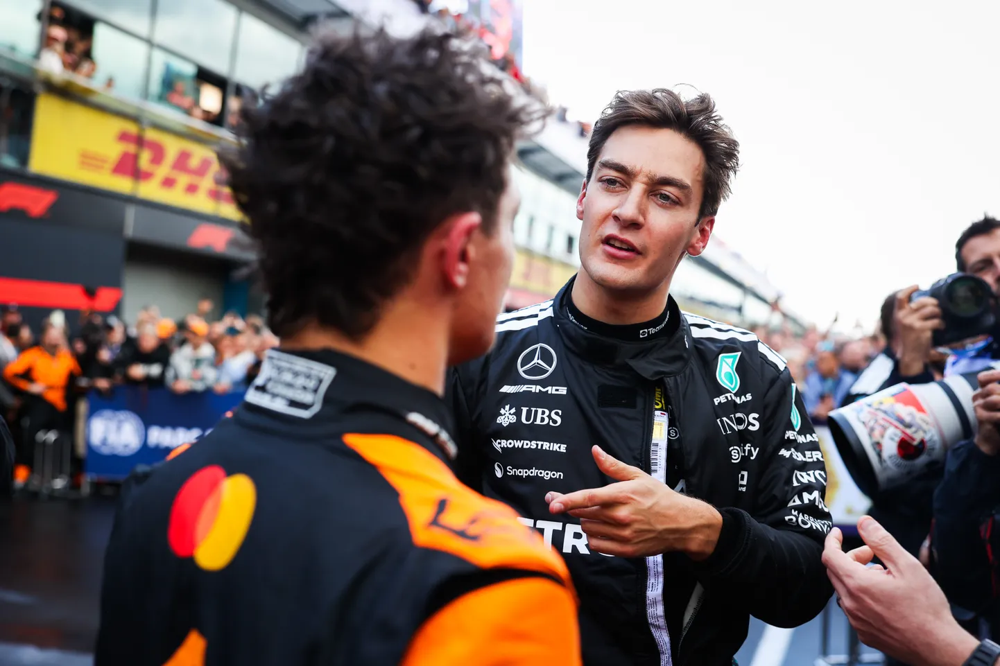 Lando Norris (seljaga) ja George Russell vestlemas.