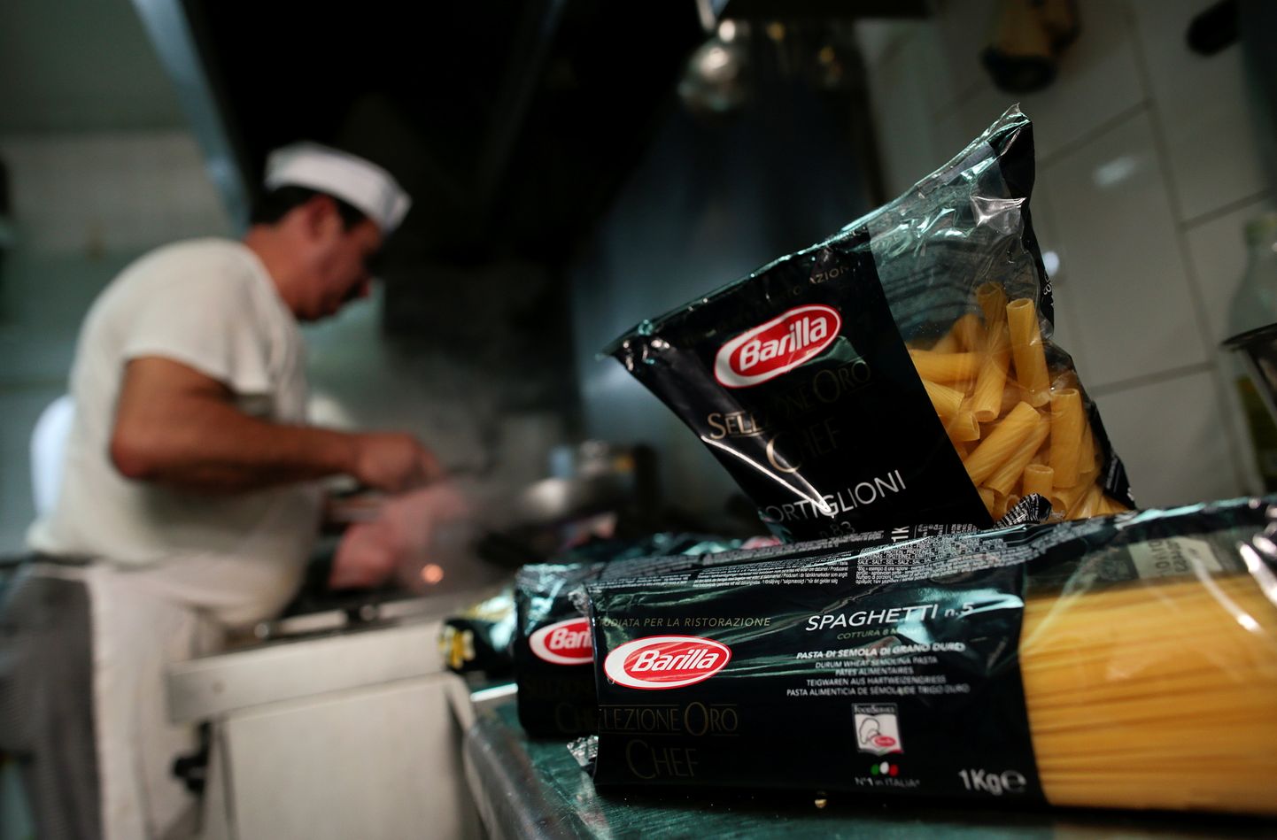 Itaalia ärimees Guido Barilla peab vabrikut ja veskit ka Venemaal. Pildil kokk Roomas restorani köögis Barilla pasta pakkide taustal toitu vaaritamas.