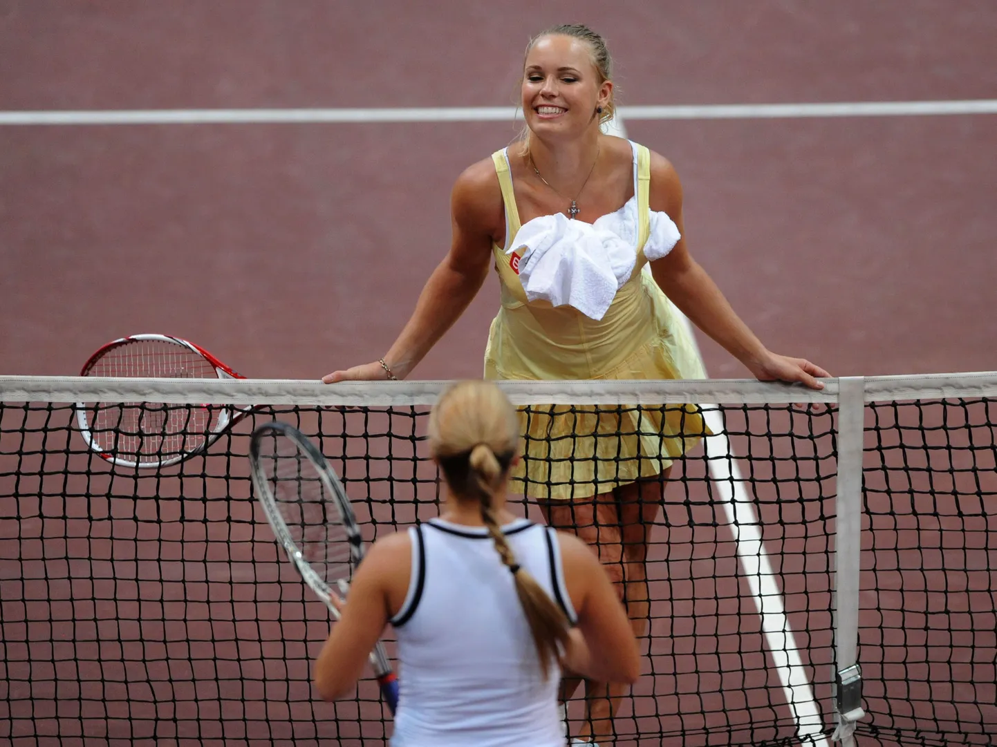 Caroline Wozniacki tenniseväljakul nalja viskamas.