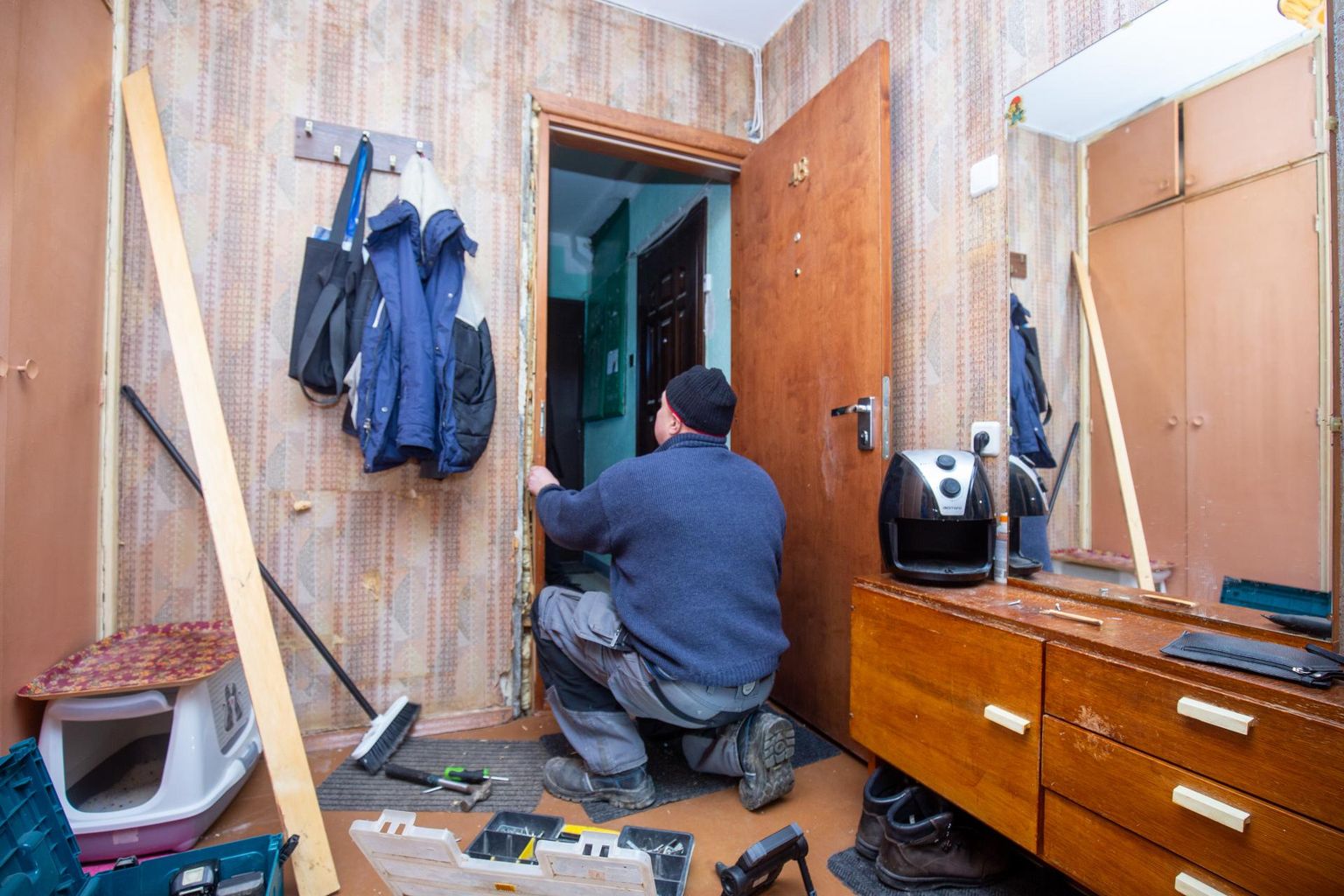 Во вторник утром рабочий ремонтировал сломанную во время происшествия входную дверь квартиры подозреваемой.