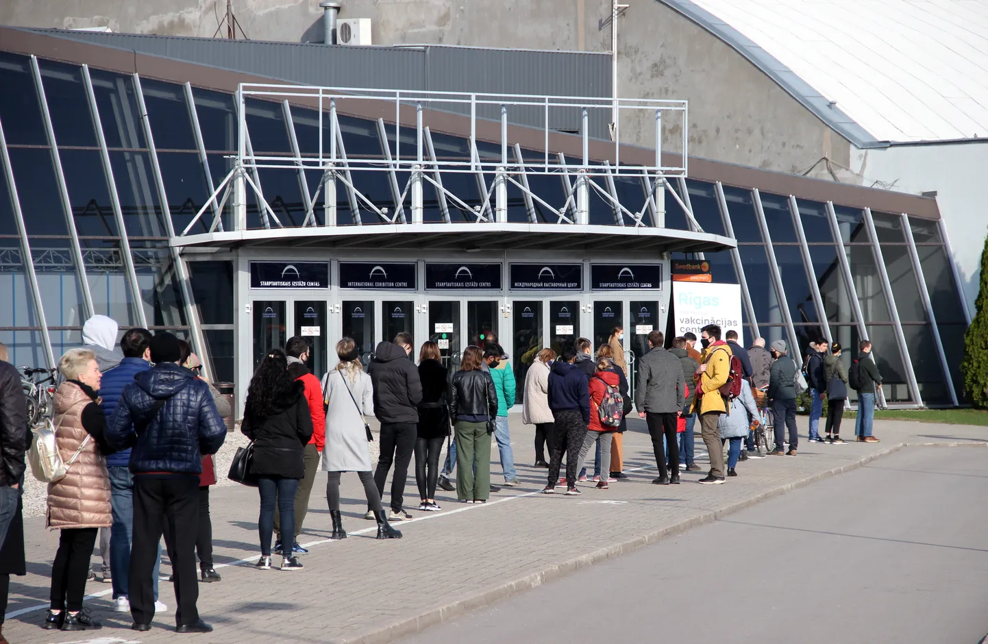 Cilvēku rinda pie masu vakcinācijas punkta Ķīpsalas izstāžu hallē, kur ikvienam iedzīvotājam iespējams saņemt vakcīnu pret "Covid-19".