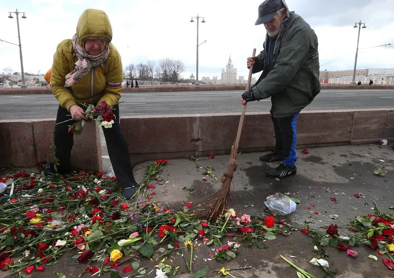 Koristamine pärast järjekordset tundmatute isikute laamendamist tema mõrvapaigas.        Foto: Scanpix