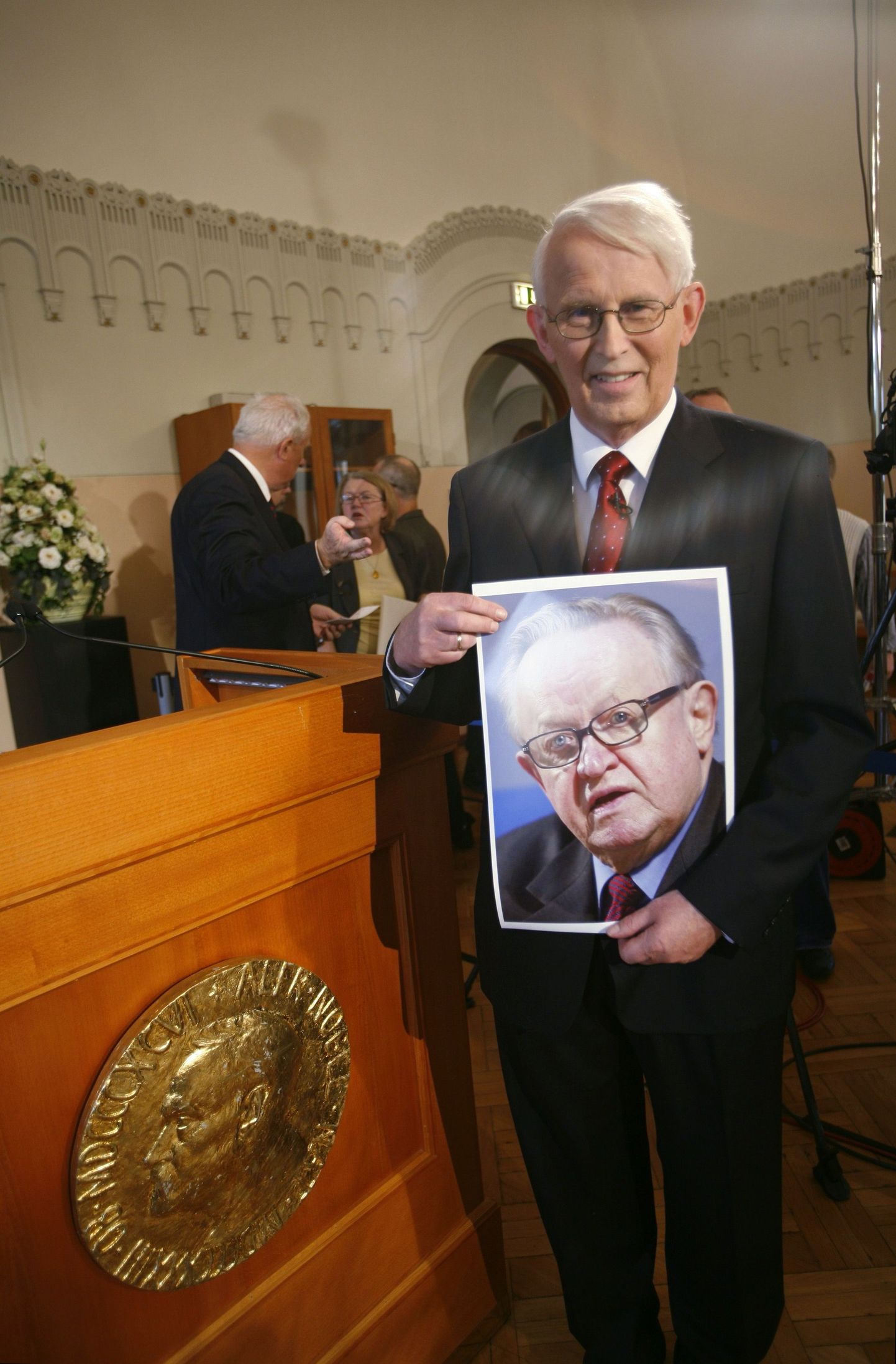 Norra Nobeli komitee esimees Ole Danbolt Mjoes näitab Martti Ahtisaari pilti pärast rahupreemia laureaadi nime avalikustamist.