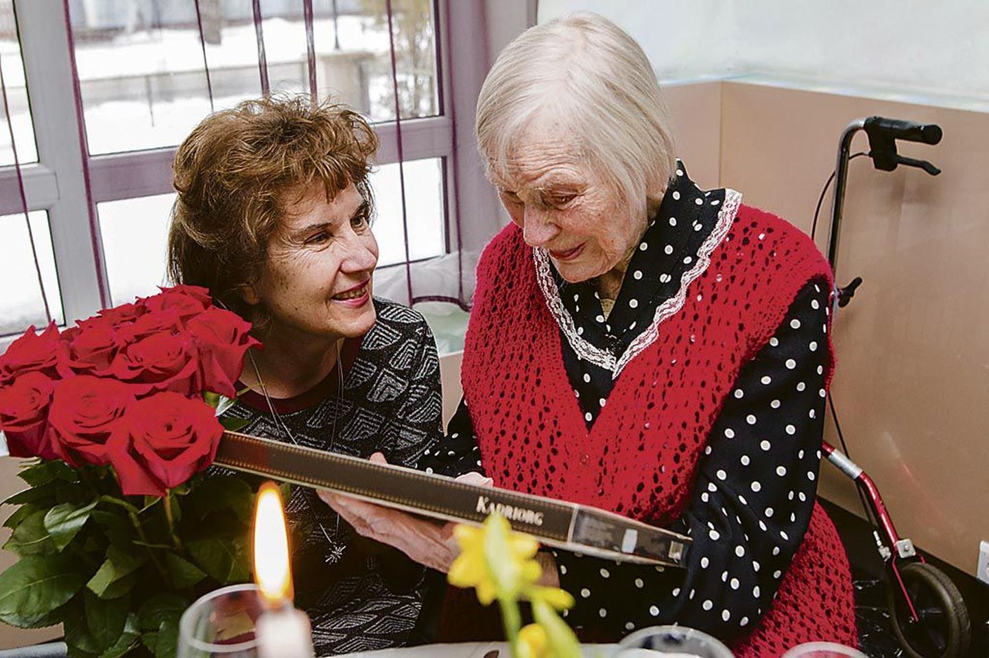 Pärnu abilinnapea Jane Mets annab 103aastaseks saanud Maire Midrile üle lilled ja kommikarbi.