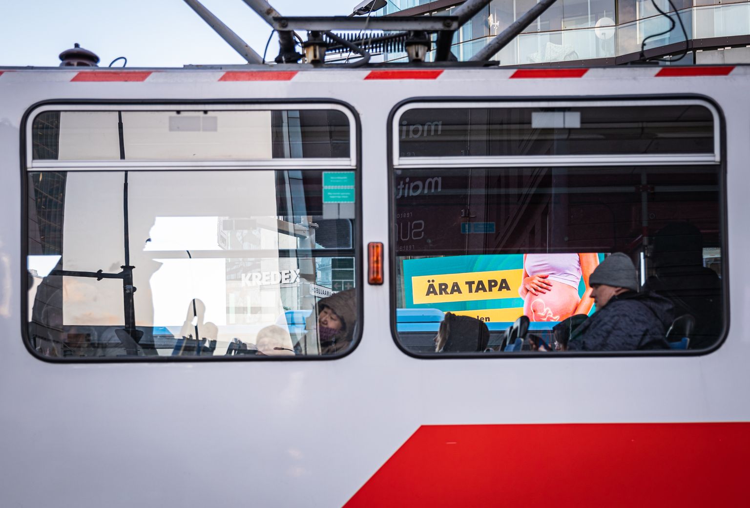 Objektiiv.ee abordivastane reklaamikampaania Hobujaamas läbi trammiakna. Ühtlasi kutsub MTÜ Elu Marss inimesi Objektiivi finantsiliselt toetama.