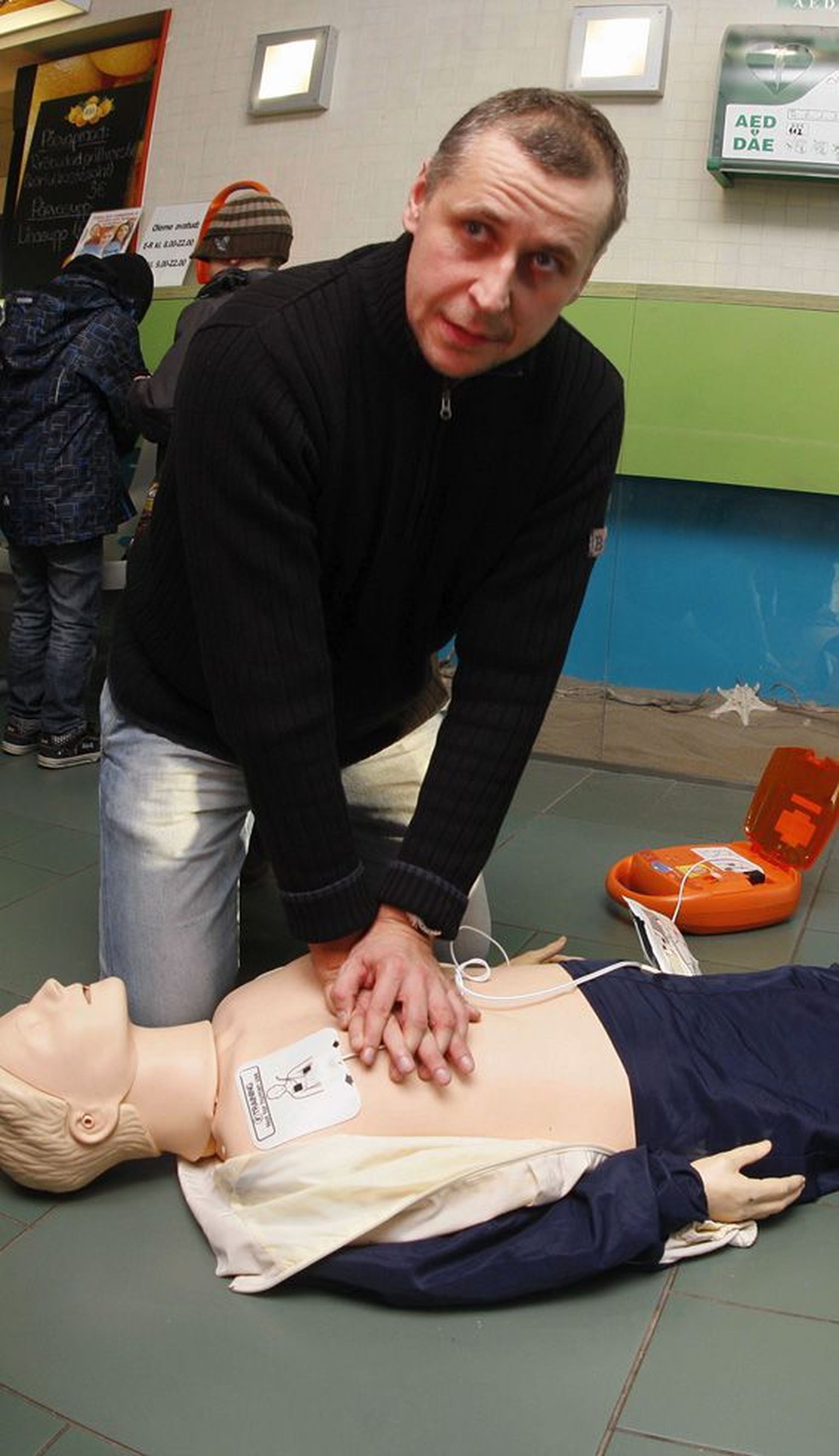 Tartu kiirabi koolitusjuht Andras Laugamets näitab nuku peal elustamisvõtteid.