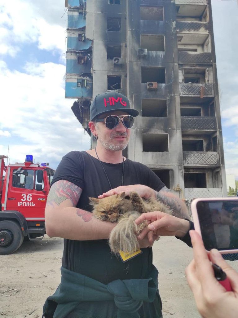 Eugene Kibets ja hoonest päästetud kass 2. mail 2022 Borodjankas Kiievis Ukrainas.